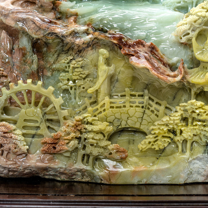 Detailed carving of Kwan Yin and mountain village in agate