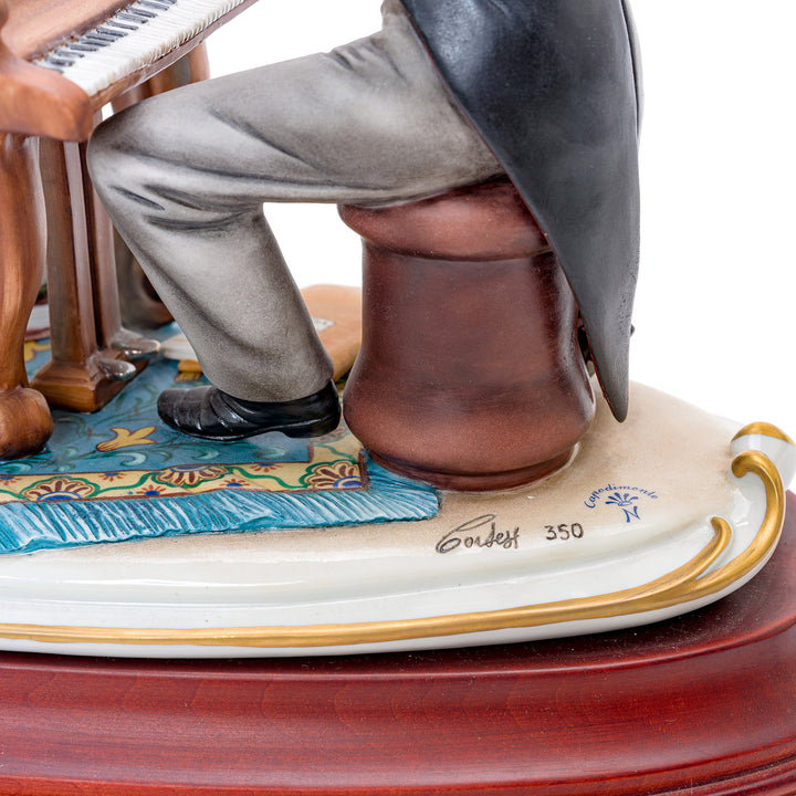 Artisan-crafted figurine of pianist in classical attire.