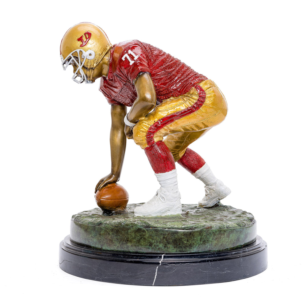 All bronze football sculpture capturing pre-play tension.