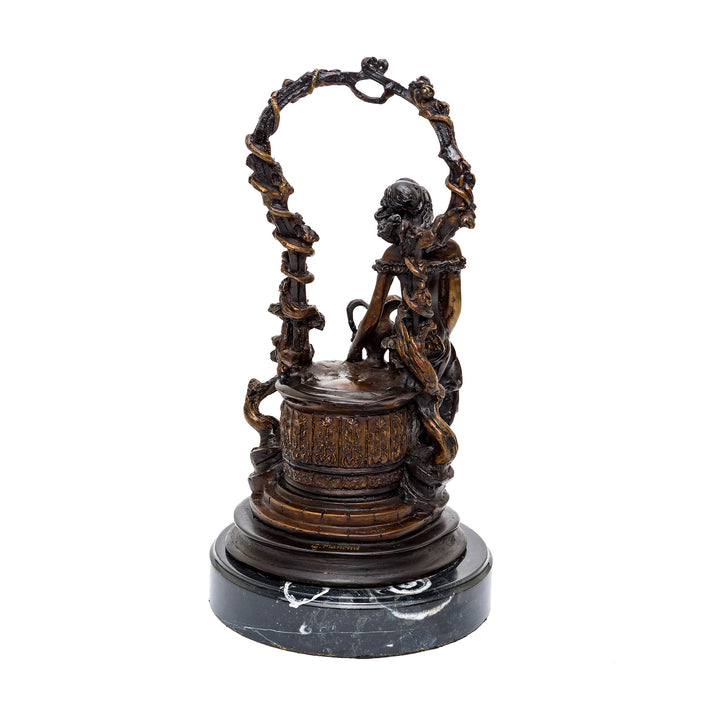 Detailed bronze art piece depicting a woman at a wishing well.