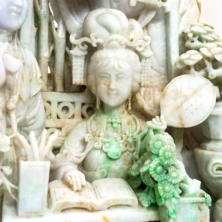 Detailed carving of jade figures and floral elements