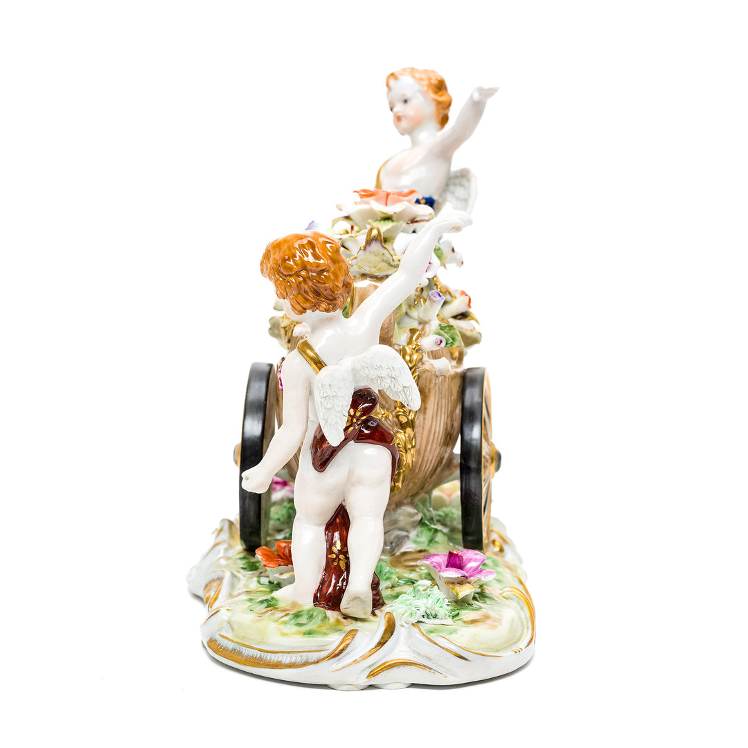 Whimsical porcelain cherubs statue on ornate base.