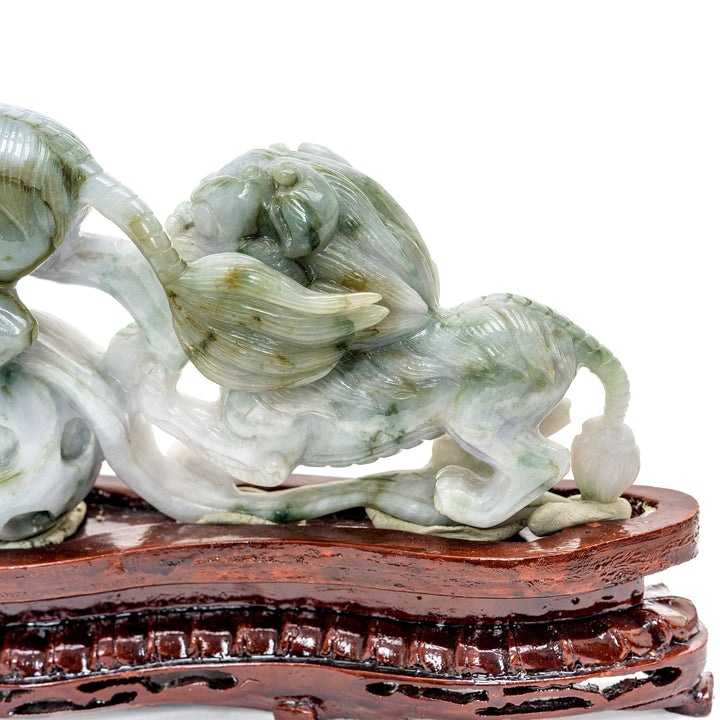 Translucent jade sculpture of mythical Foo Lions on ornate wooden stand