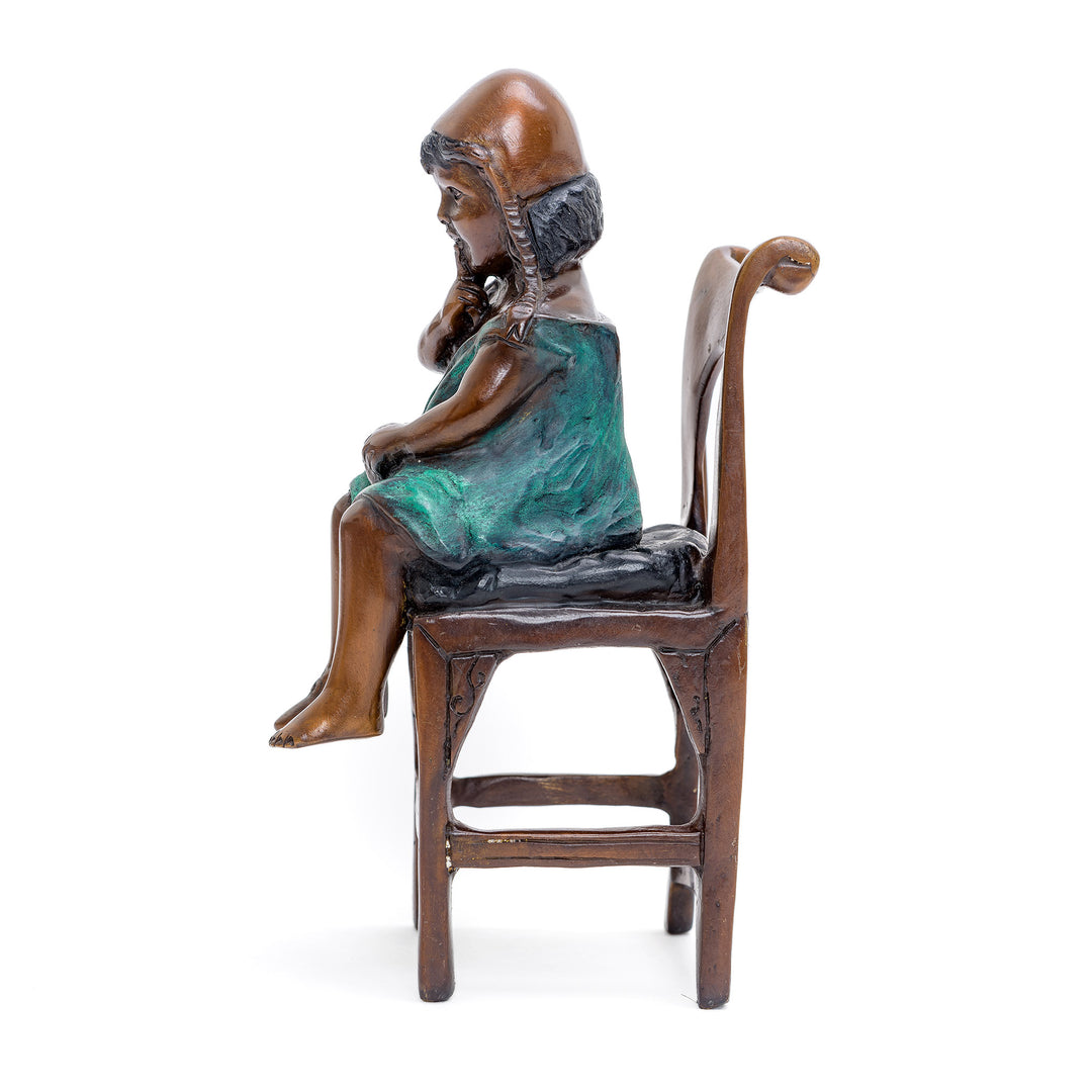 Contemplative child figure, a delicate bronze artwork.