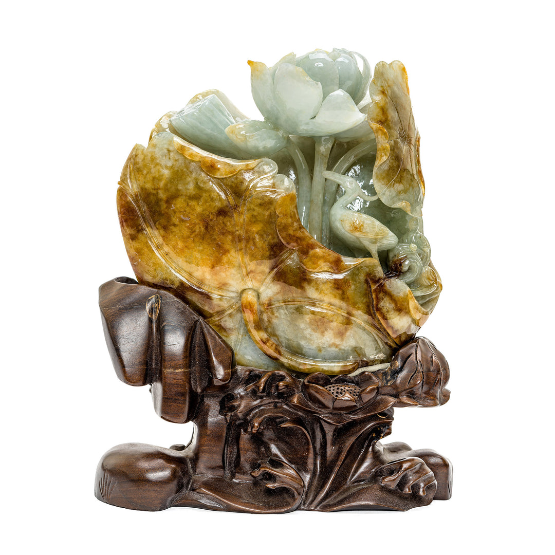 Hand-carved jade sculpture of a lotus flower and crane on a wooden base