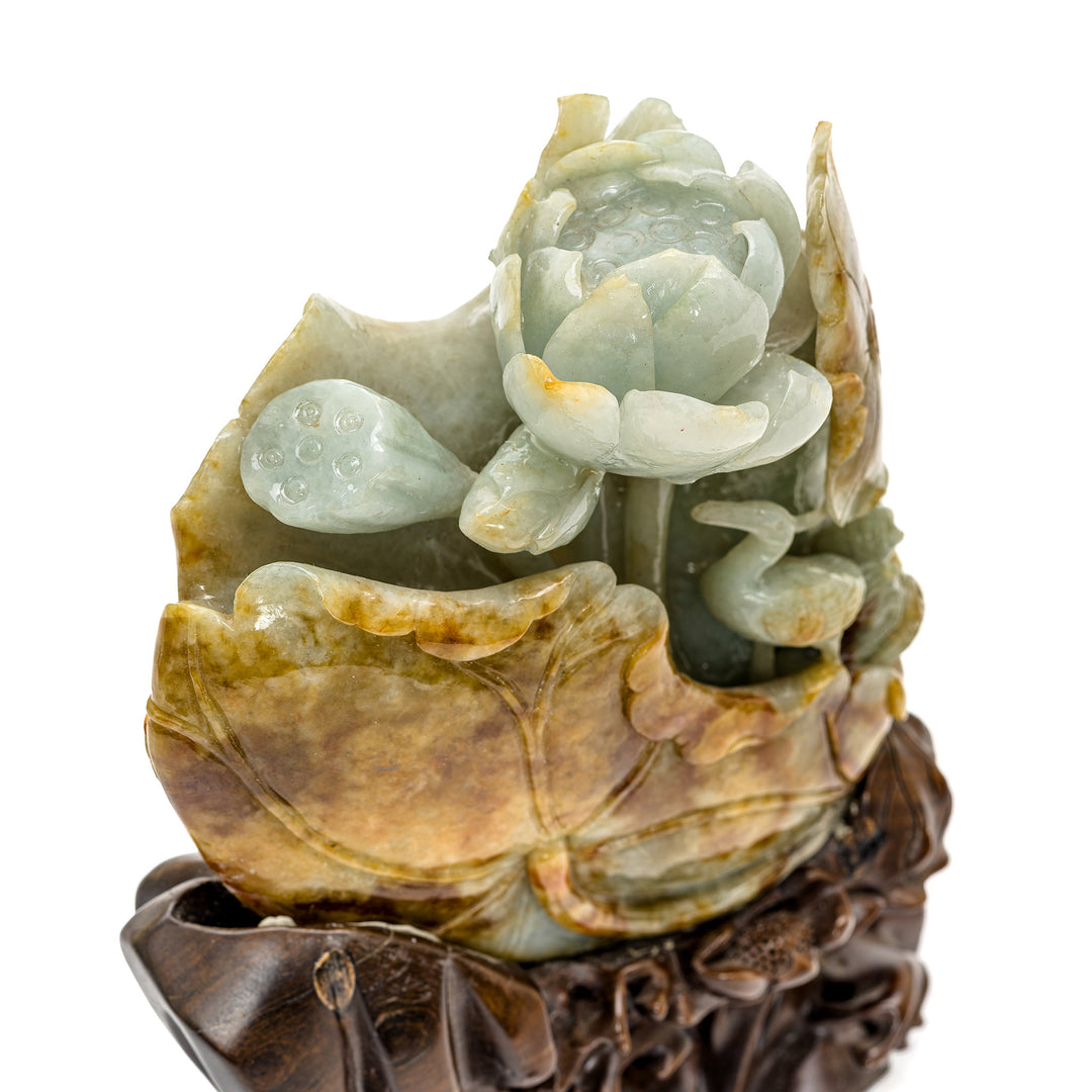 Intricately carved lotus and crane from a solid piece of jade, on a fitted wooden base