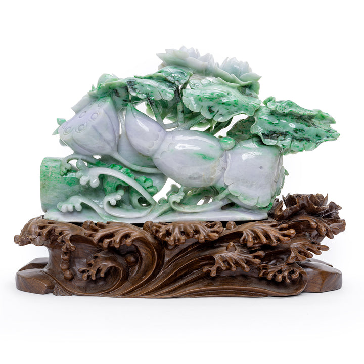 Dimensional jade carving with natural green and lavender hues on a wooden base