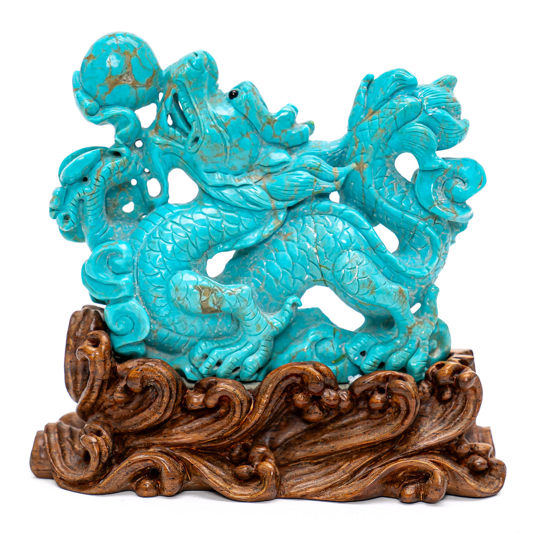 Hand-carved turquoise dragon atop wooden base.