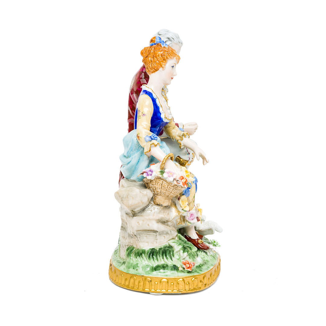 Detailed porcelain couple with colorful attire and doves.
