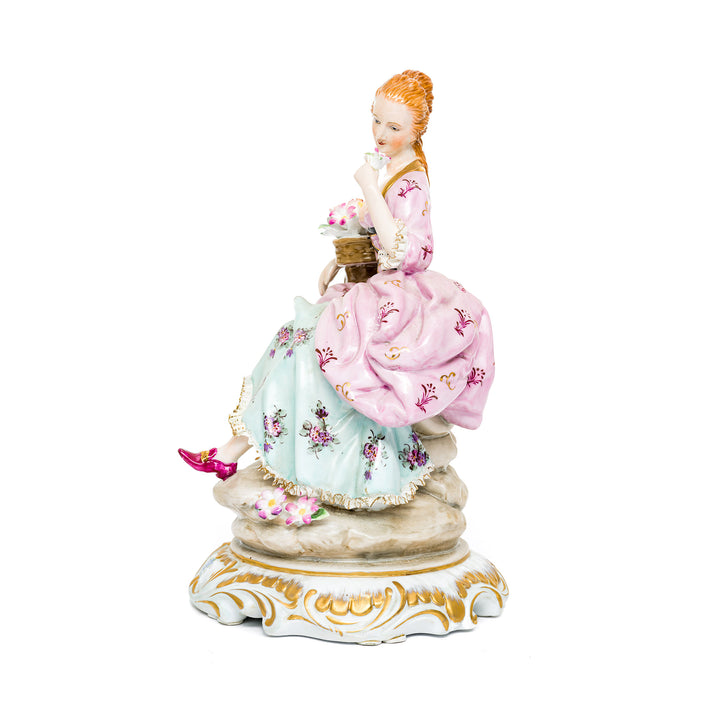 Elegant porcelain figurine of a lady in pink and blue dress.