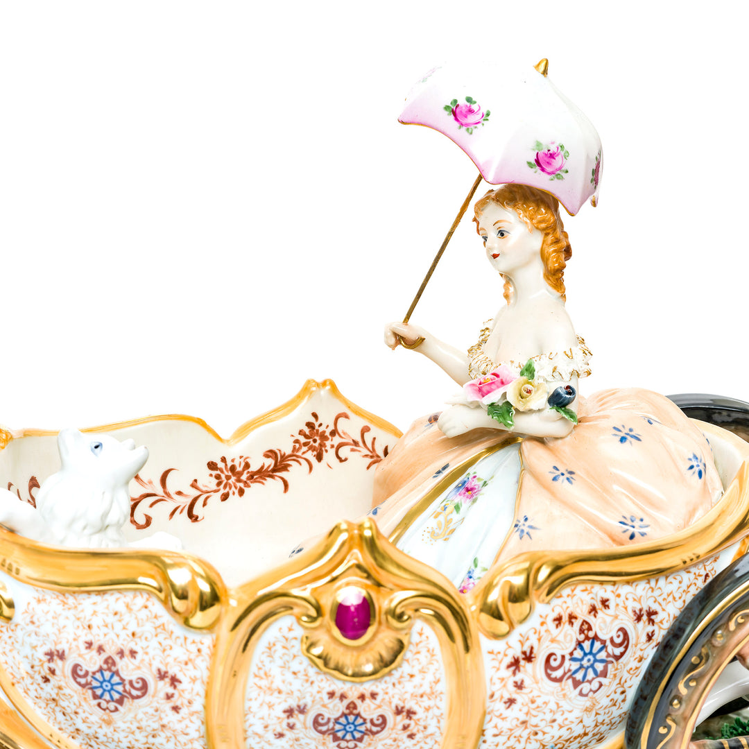 Elegant white horses pulling a detailed Cinderella Carriage in a porcelain sculpture.