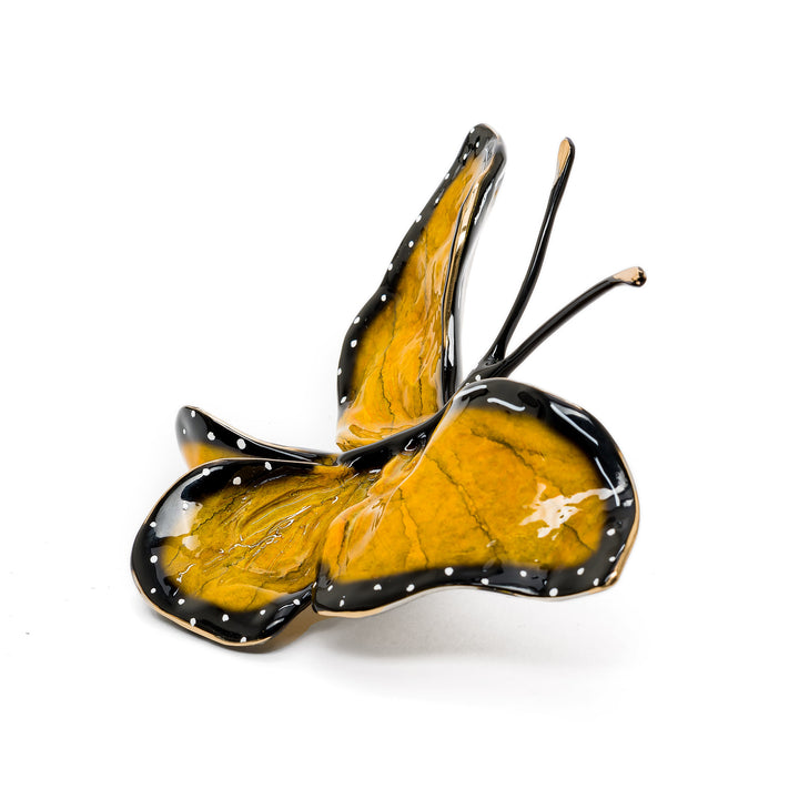 Side angle of enamel butterfly showing elegant arching wings