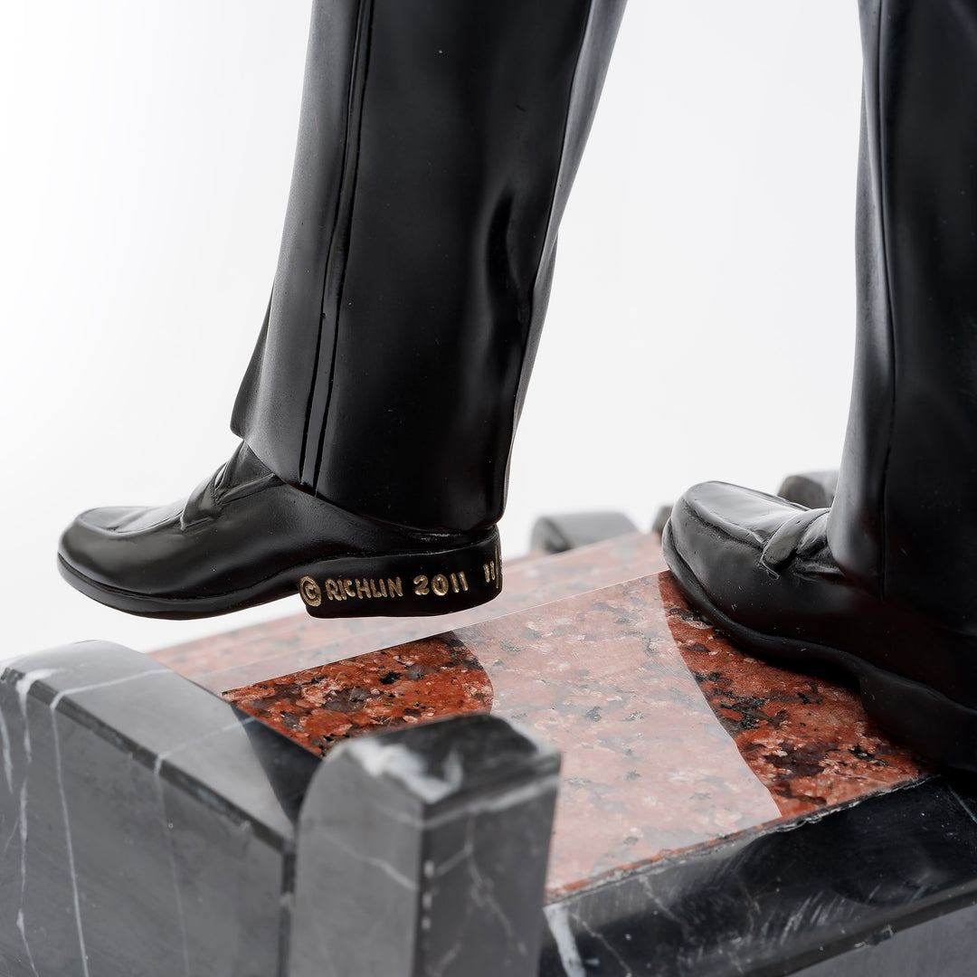 Close-up of Dean Martin bronze shoes and marble staircase details