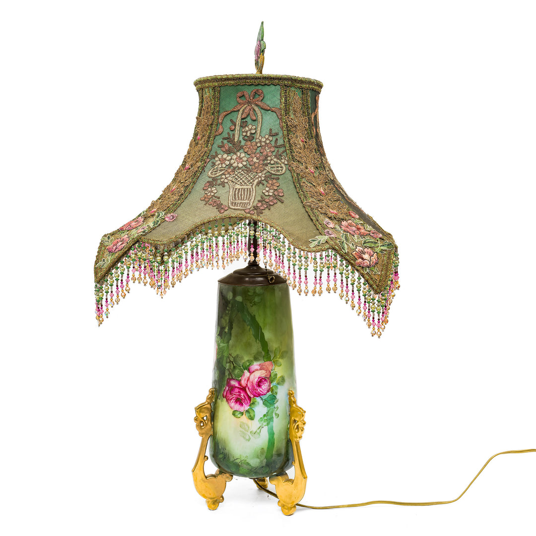 Elegant antique lamp with ornate gold feet and floral design