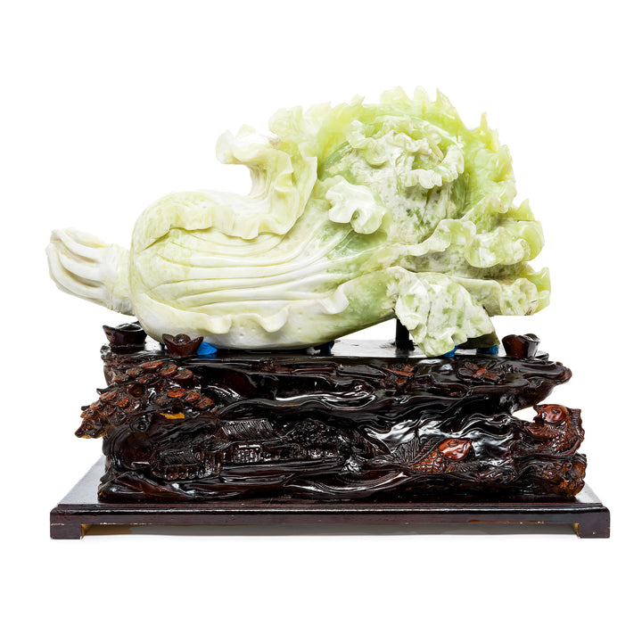 Hand-carved serpentine cabbage sculpture on carved wooden base.