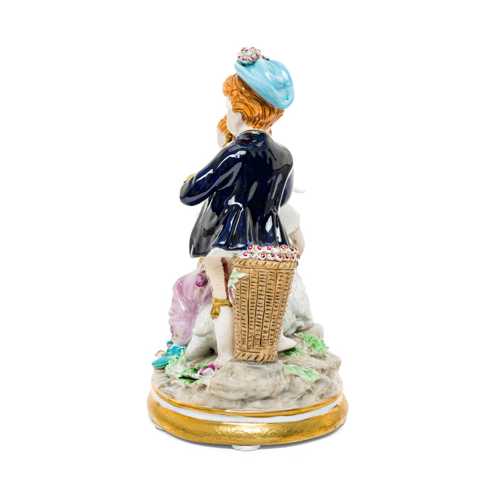 Hand-painted porcelain figurine of two children with a goat, one playing a flute, crafted in fine German porcelain.