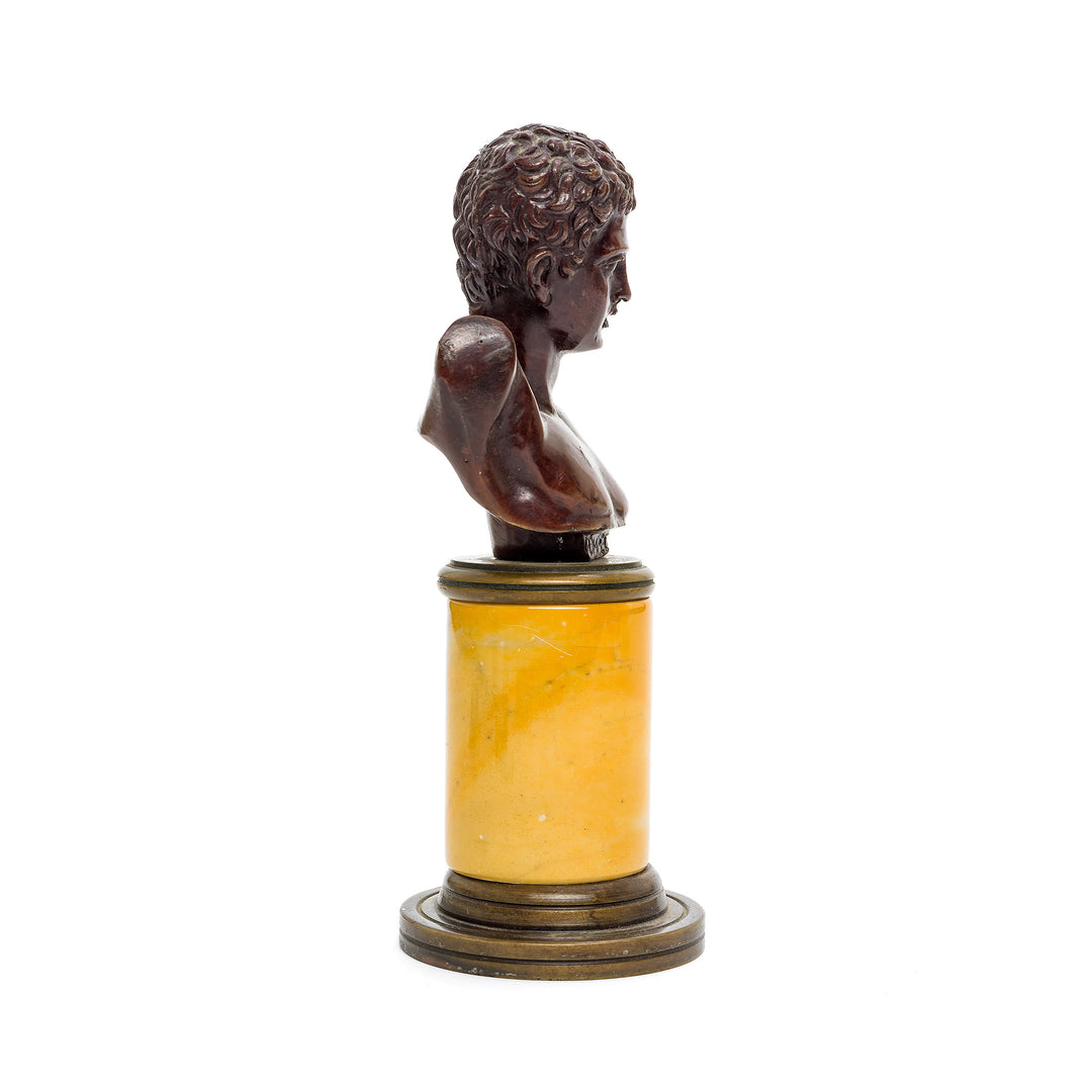 Italian classical bronze bust on warm-toned marble, capturing youthful beauty.