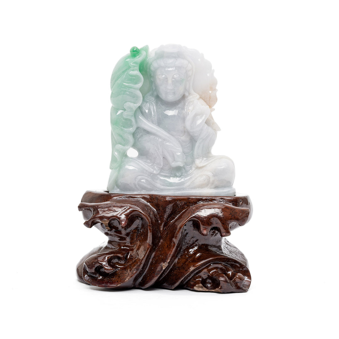 Jade Guan Yin sculpture sitting amidst carved foliage