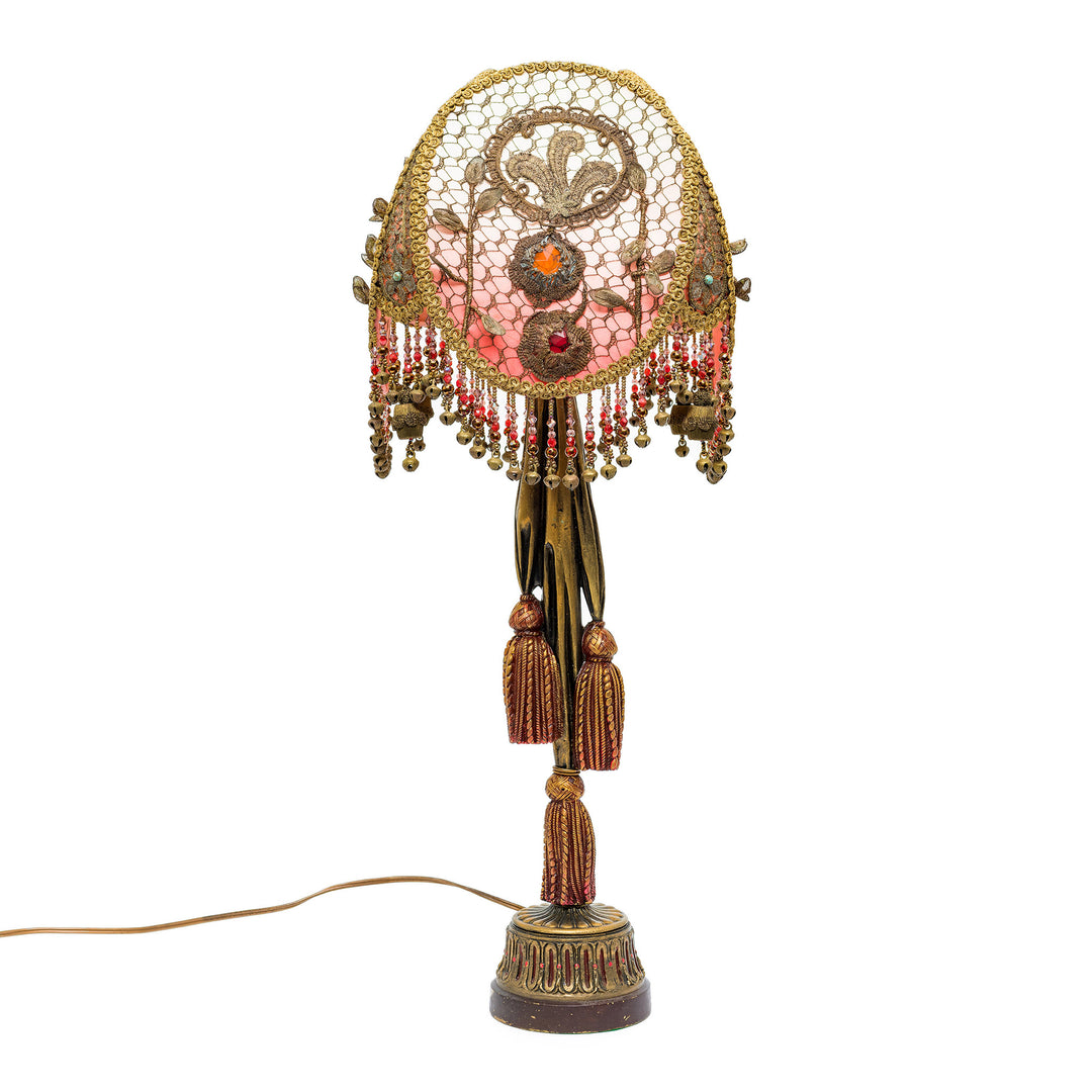 Decorative lamp with intricate design and tassels on a white background