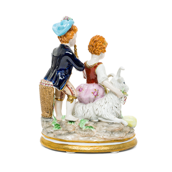 Musical pastoral scene German porcelain figurine featuring a boy playing a flute and a girl seated on a goat.