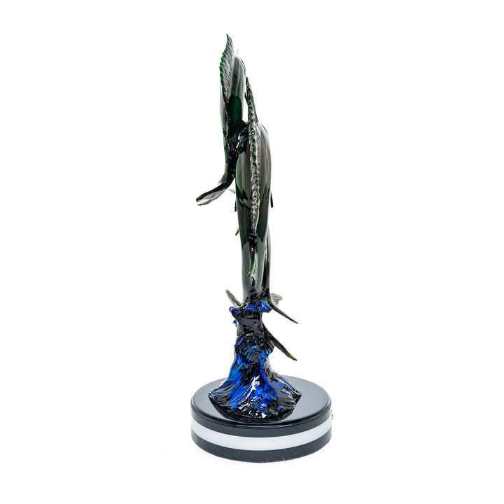 Sailfish statue with a wave-like blue base and bronze sculpted fish.