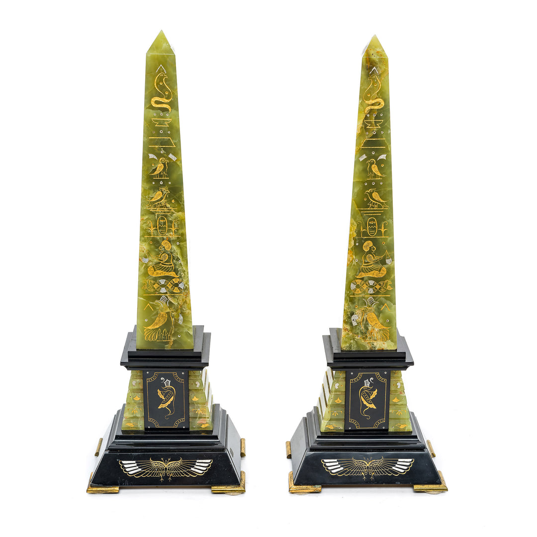 Pair of green onyx obelisks with gold engravings and black marble bases.