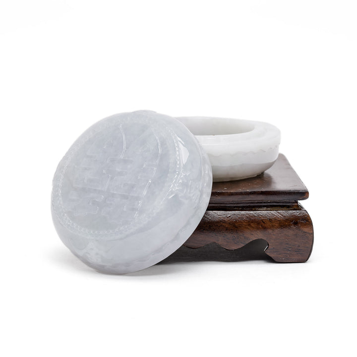 Open jade box with engraved lid beside base
