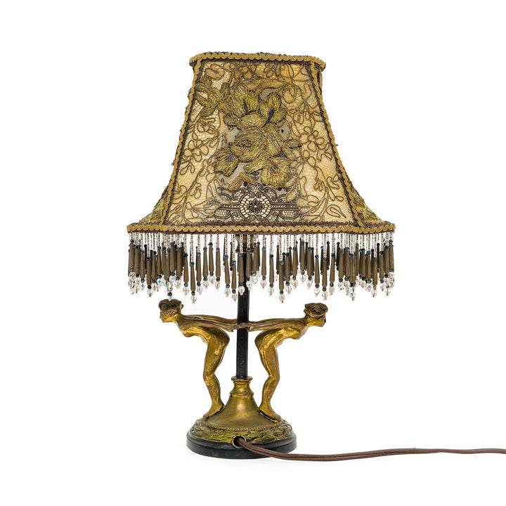 Ornate bronze lamp with embroidered lace shade