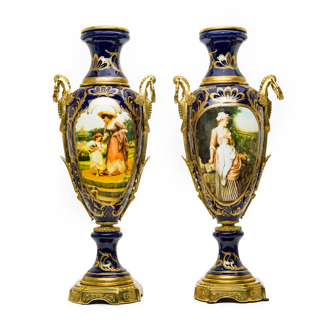 Pair of cobalt porcelain vases with gilded ormolu handles and hand-painted panels