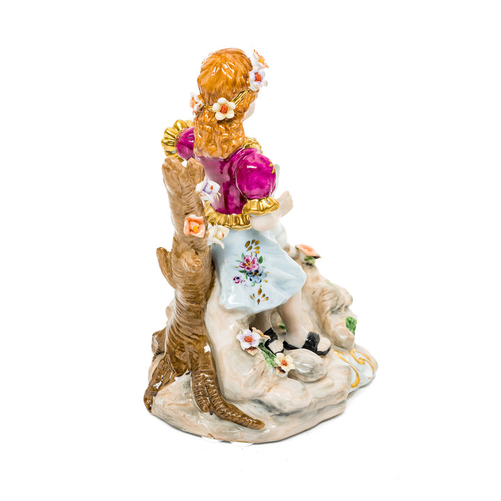 German porcelain figurine featuring a playful scene of a young girl and her kitten with colorful hand-painted details.