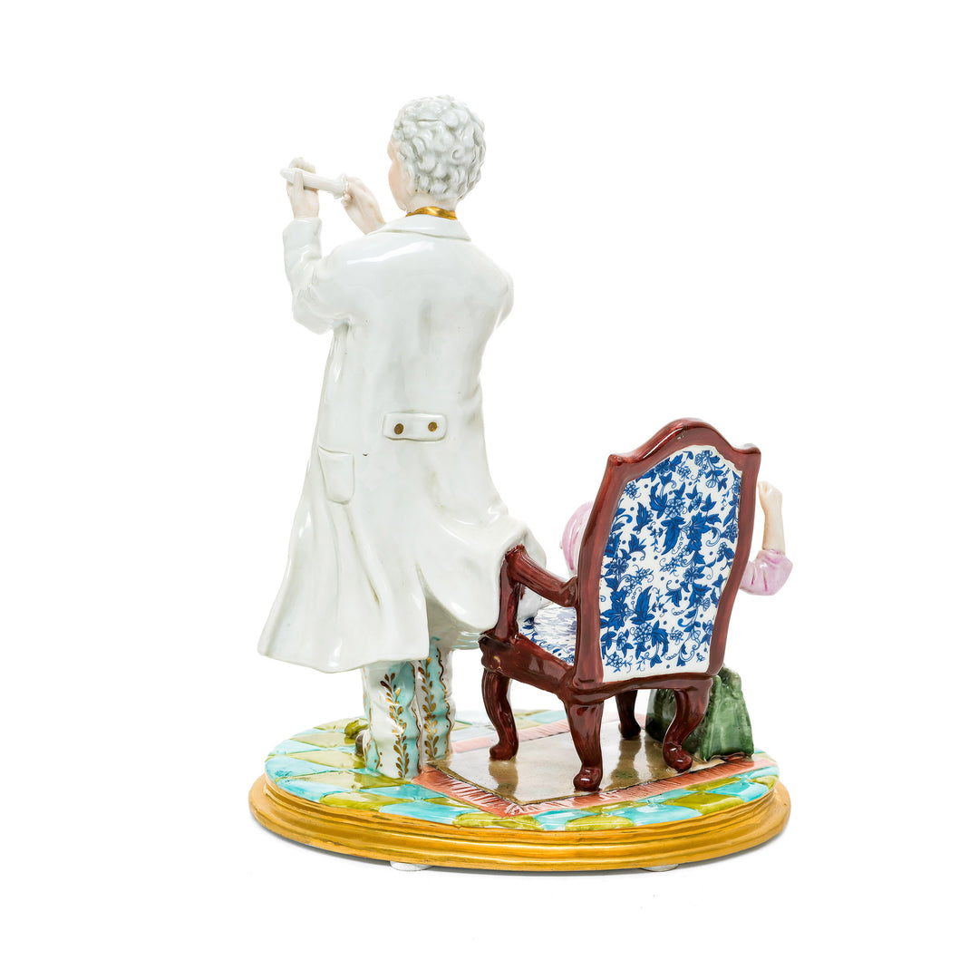 Playful German porcelain figurine featuring a humorous doctor and patient scene with vibrant details.