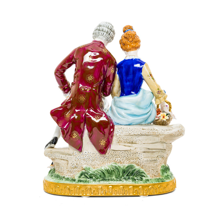 Romantic German porcelain figurine depicting a courting couple with floral and nature-inspired details.