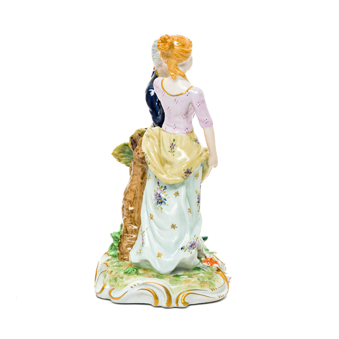 Romantic German porcelain figurine featuring a couple sharing an intimate moment with a lamb at their feet.