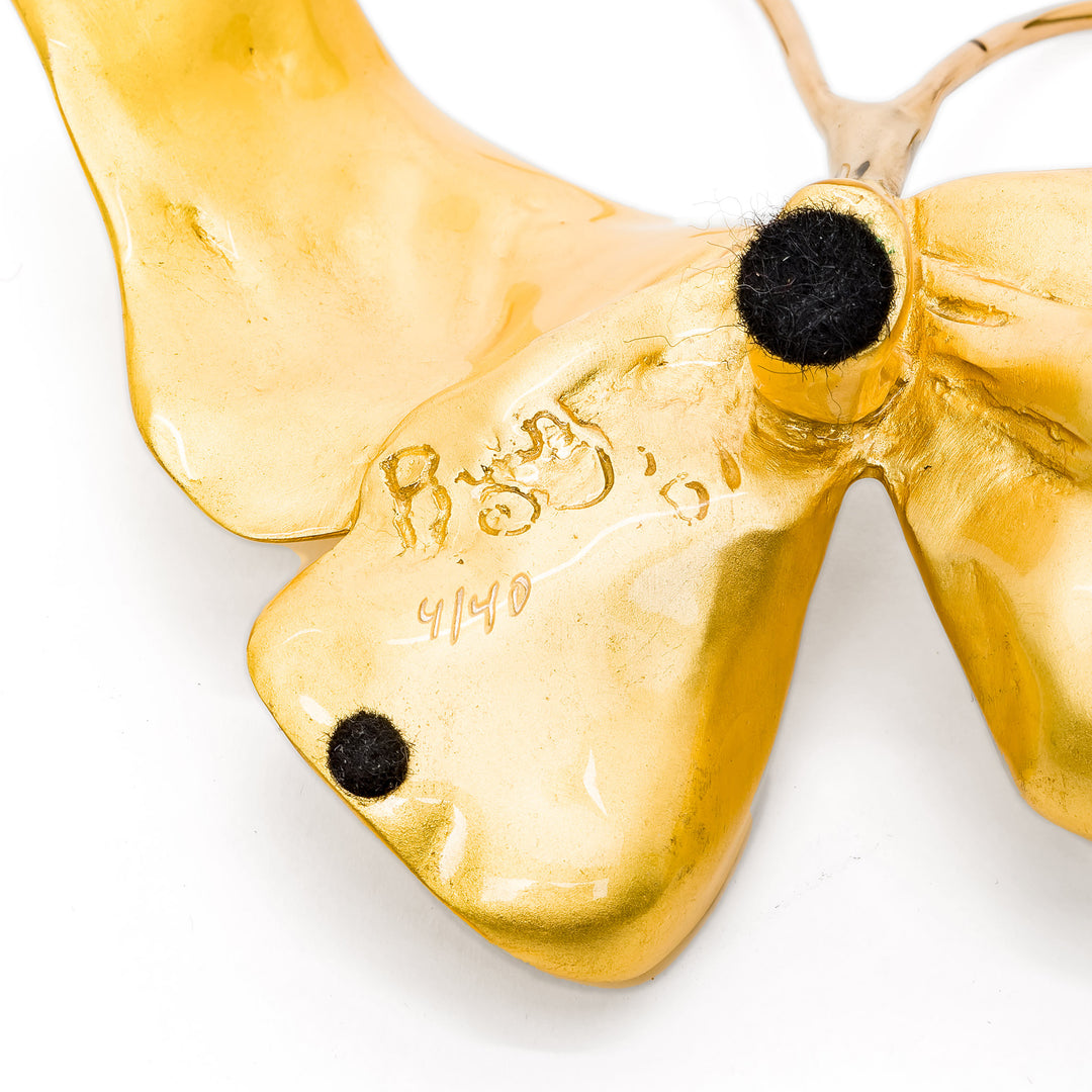 Underside of bronze butterfly sculpture with artist signature