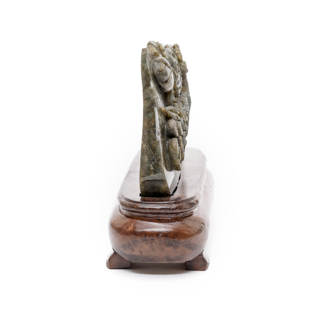 Side view of peacock crystal carving on wood base