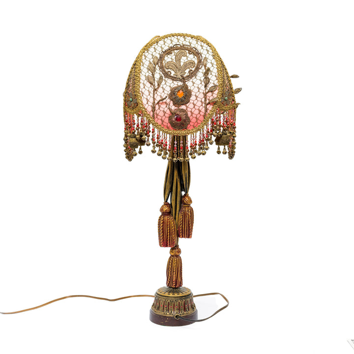 Decorative lamp with intricate design and tassels on a white background