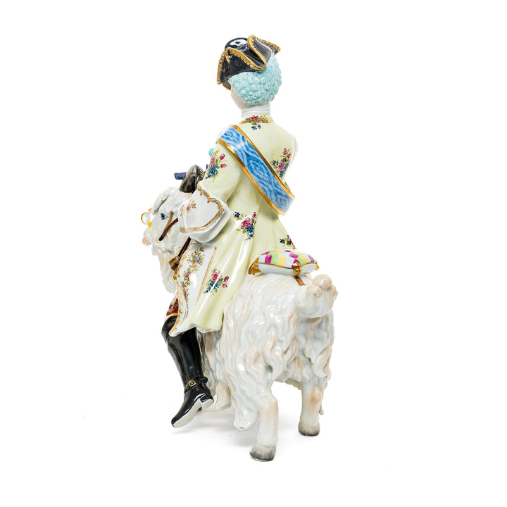 Whimsical German porcelain figurine of a nobleman riding a goat with golden accents.