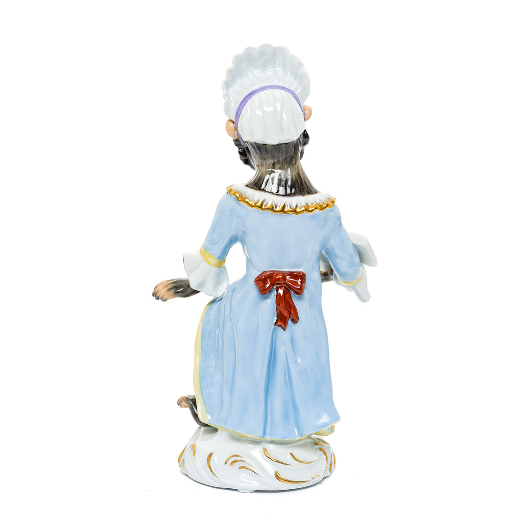 Whimsical German porcelain figurine featuring a monkey in conductor’s attire holding sheet music.